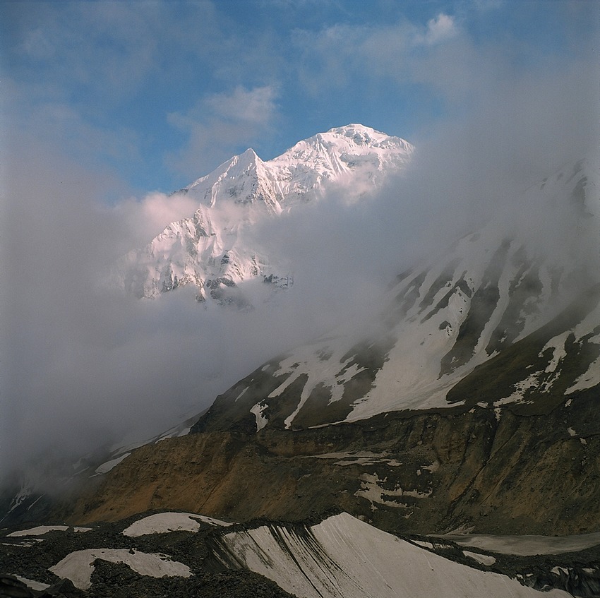 Hiunchuli (6441m) zza chmur nad lodowcem Annapurny