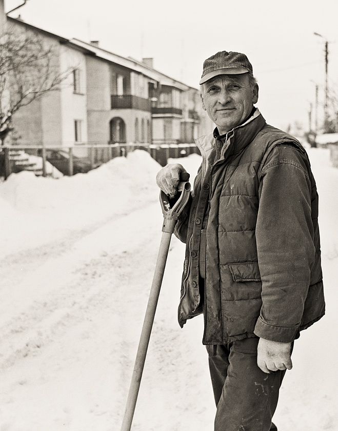 Portret człowieka, zmagającego się ze śniegiem, zalegającym posesję